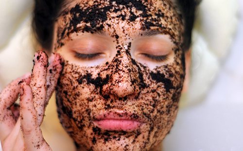 The girl has smeared herself with coffee grounds and lies with her eyes closed