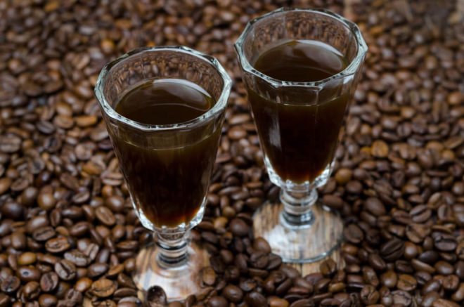 two glasses with dark liqueur and coffee beans