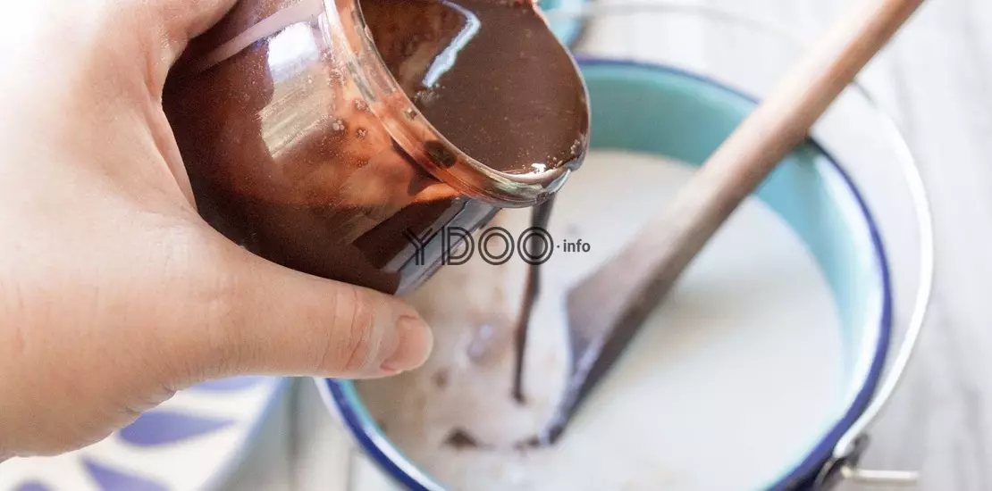 cocoa mass is poured into a container with milk